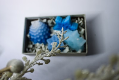 Elegant soap flower boxes displayed on a wooden table with soft lighting
