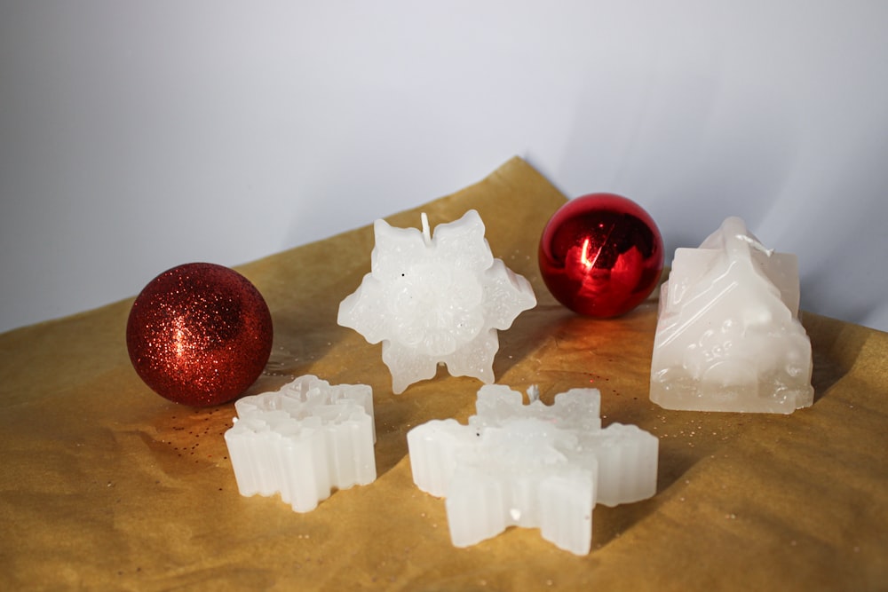 a red ornament sitting next to a couple of white pieces of ice