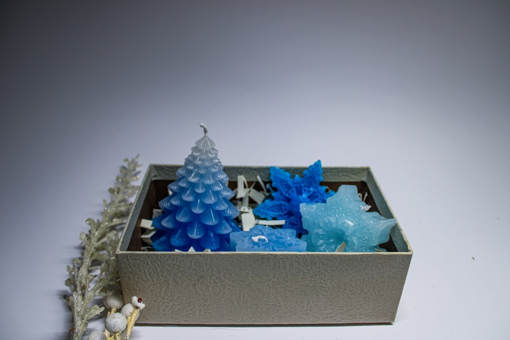 Una caja llena de árboles de Navidad esmerilados azules y blancos