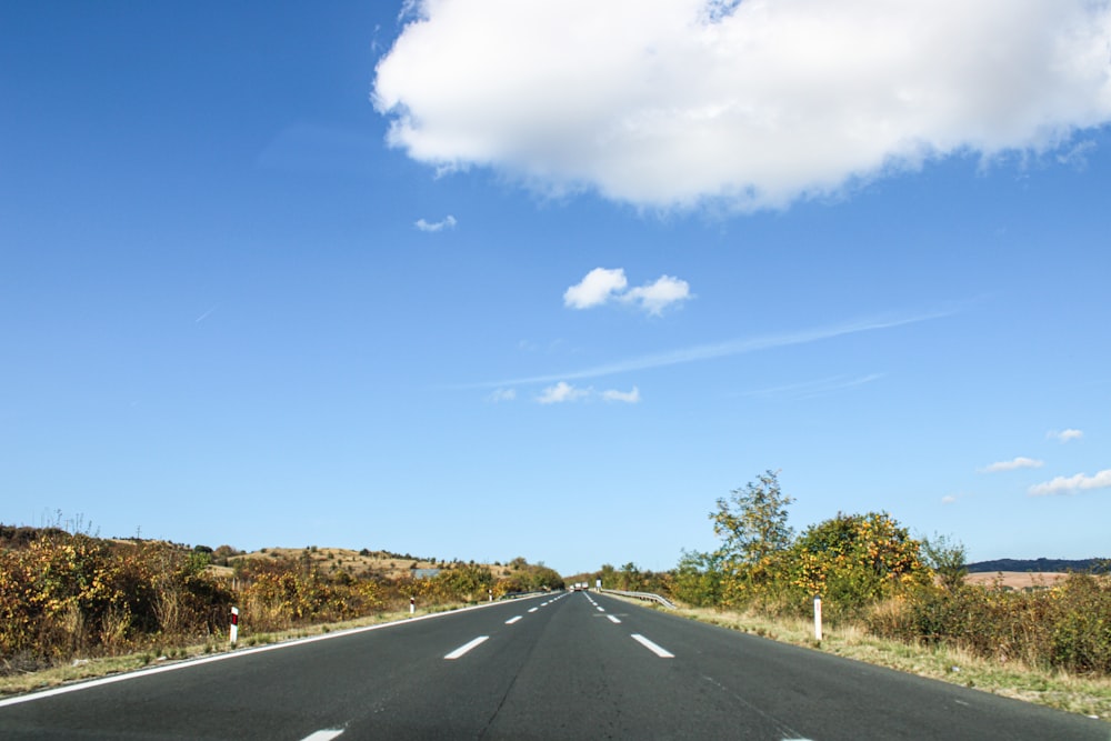 an empty road with a blue sky in the background