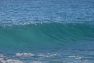 A gentle wave rolling onto a quiet beach, symbolizing the natural rhythm of breath.