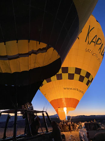 A group of happy travelers preparing for a hot air balloon flight at dawn