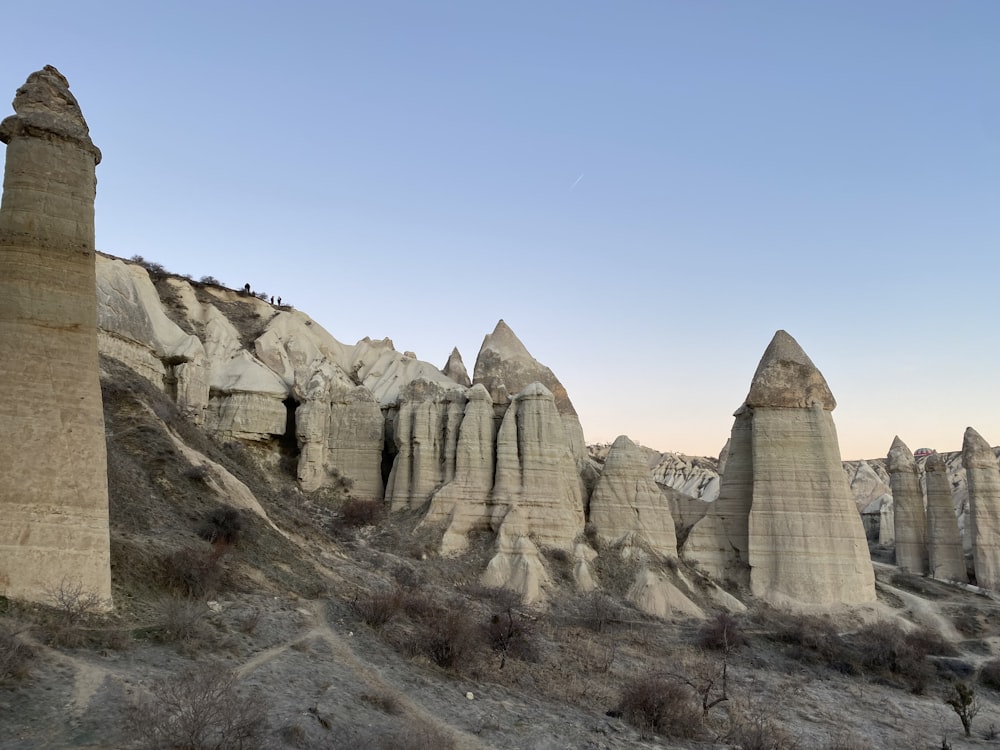 a group of tall rocks sitting on top of a hillside