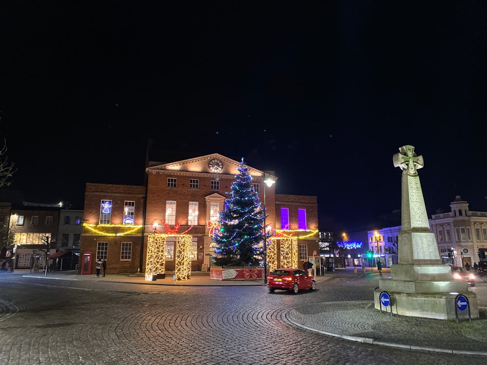 a christmas tree is lit in front of a building