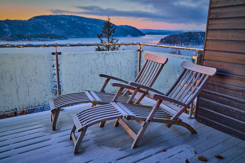 a couple of wooden chairs sitting on top of a wooden deck