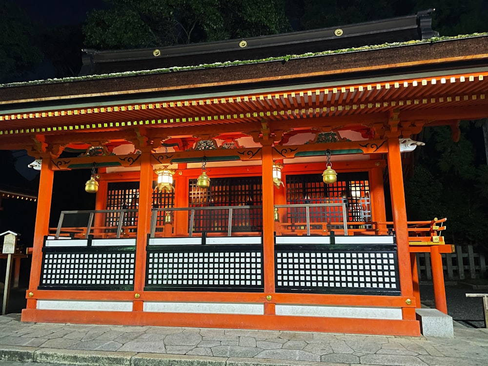 a red and white building with lanterns hanging from it's roof