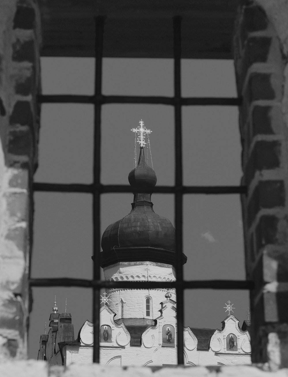 a black and white photo of a church through a window