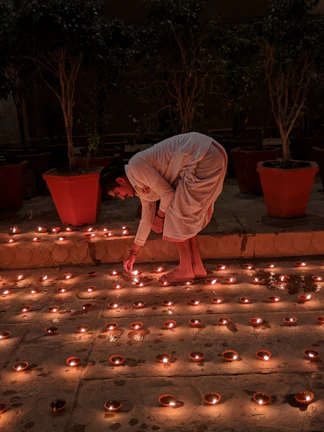Devotees lighting traditional oil lamps during a serene evening prayer.