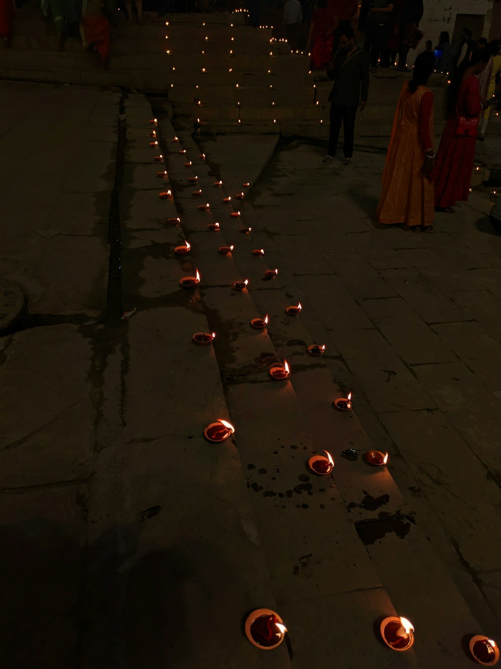 a row of candles sitting on top of a sidewalk