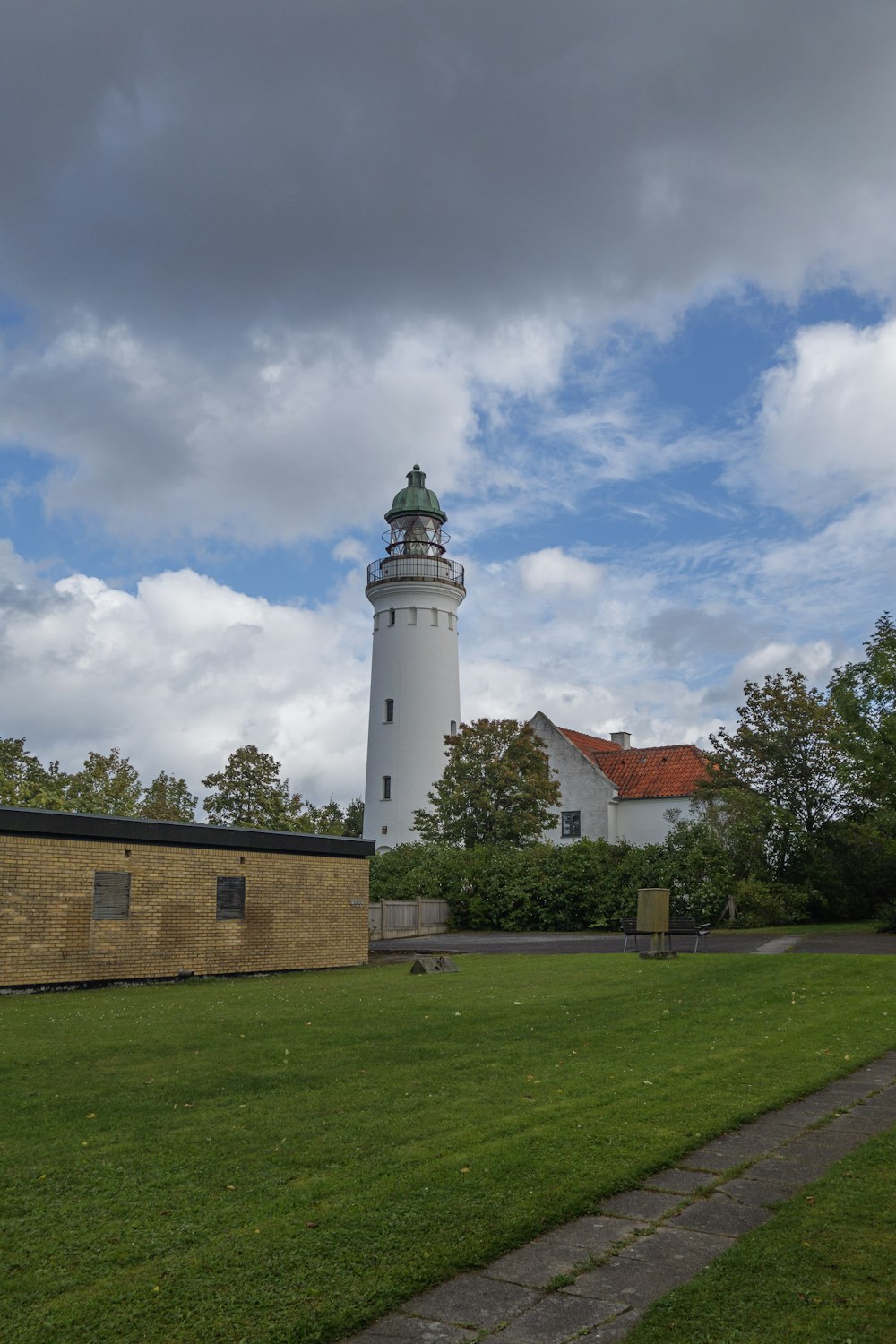 a large white lighthouse sitting on top of a lush green field