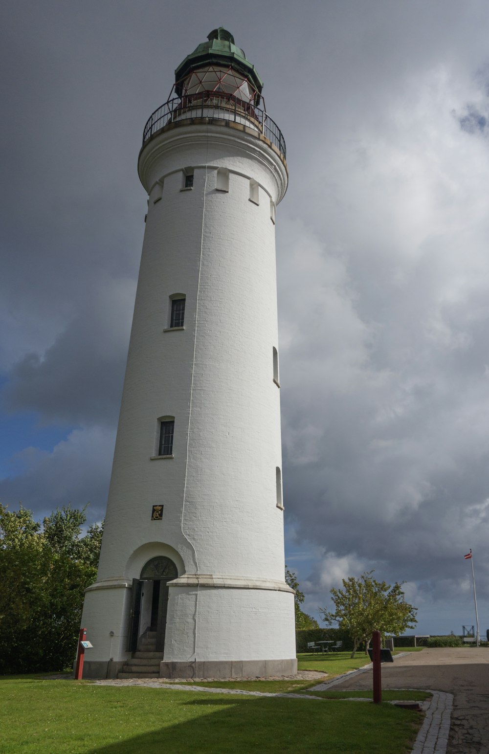 a large white lighthouse sitting on top of a lush green field