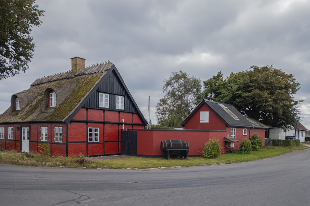 a red and black house with a thatched roof