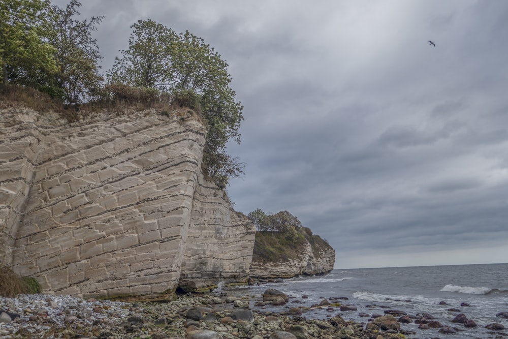 a large rock formation on the shore of a body of water