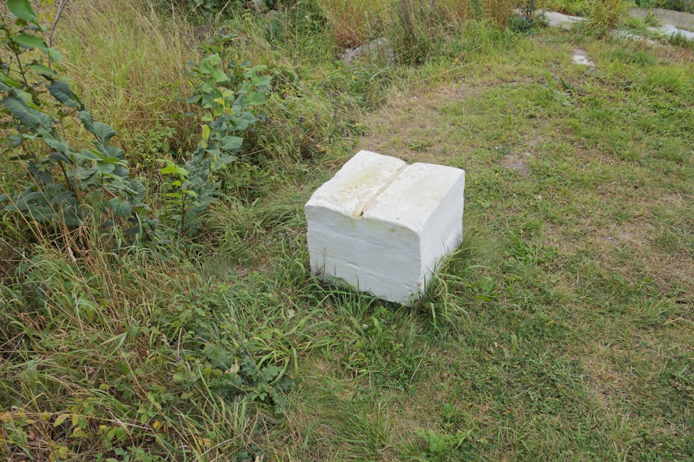 a white box sitting in the middle of a field