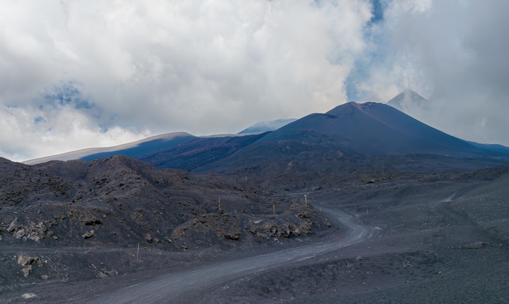 a dirt road with a mountain in the background