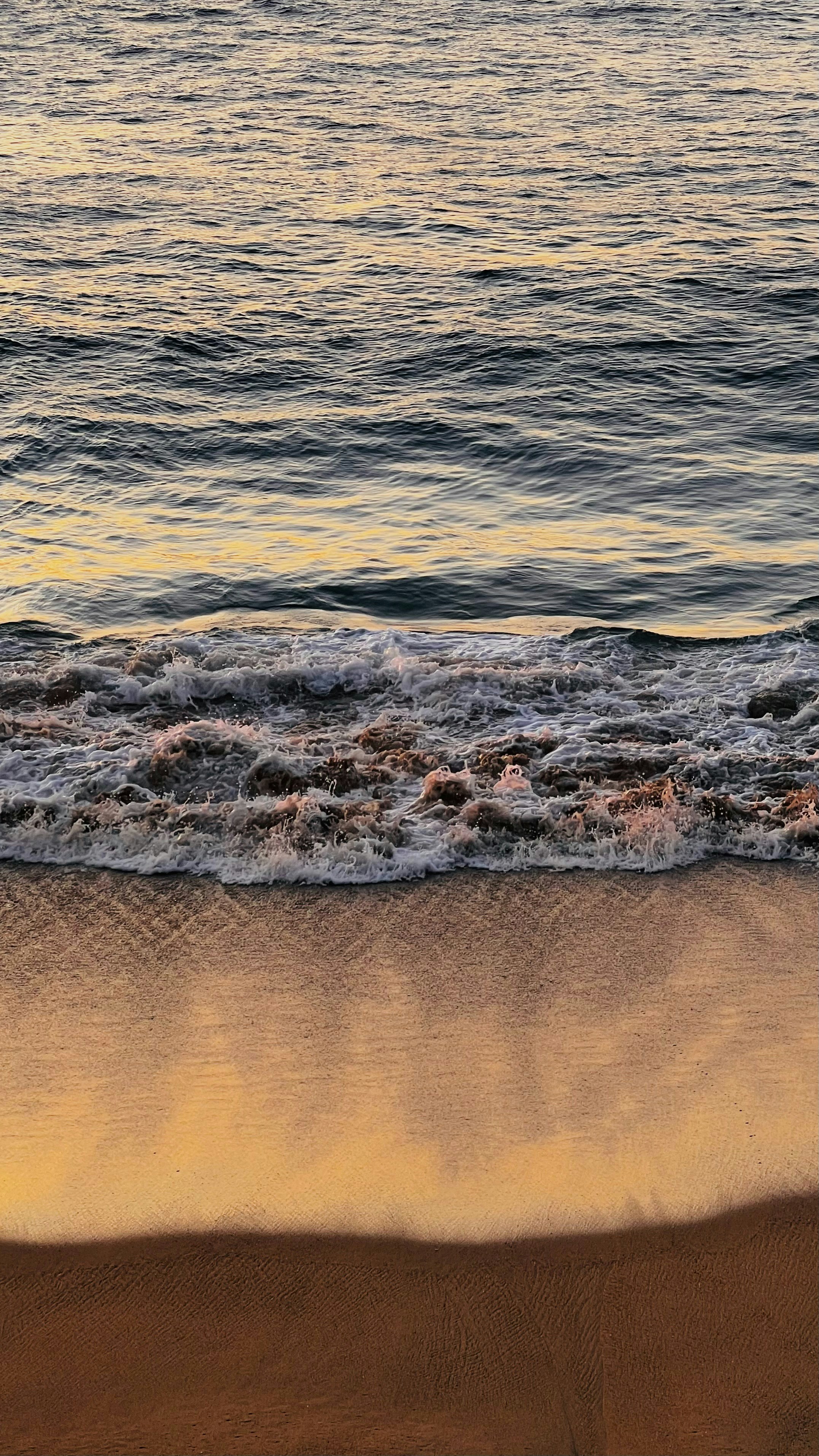 A beach with waves coming in to shore photo – Free Brown Image on Unsplash