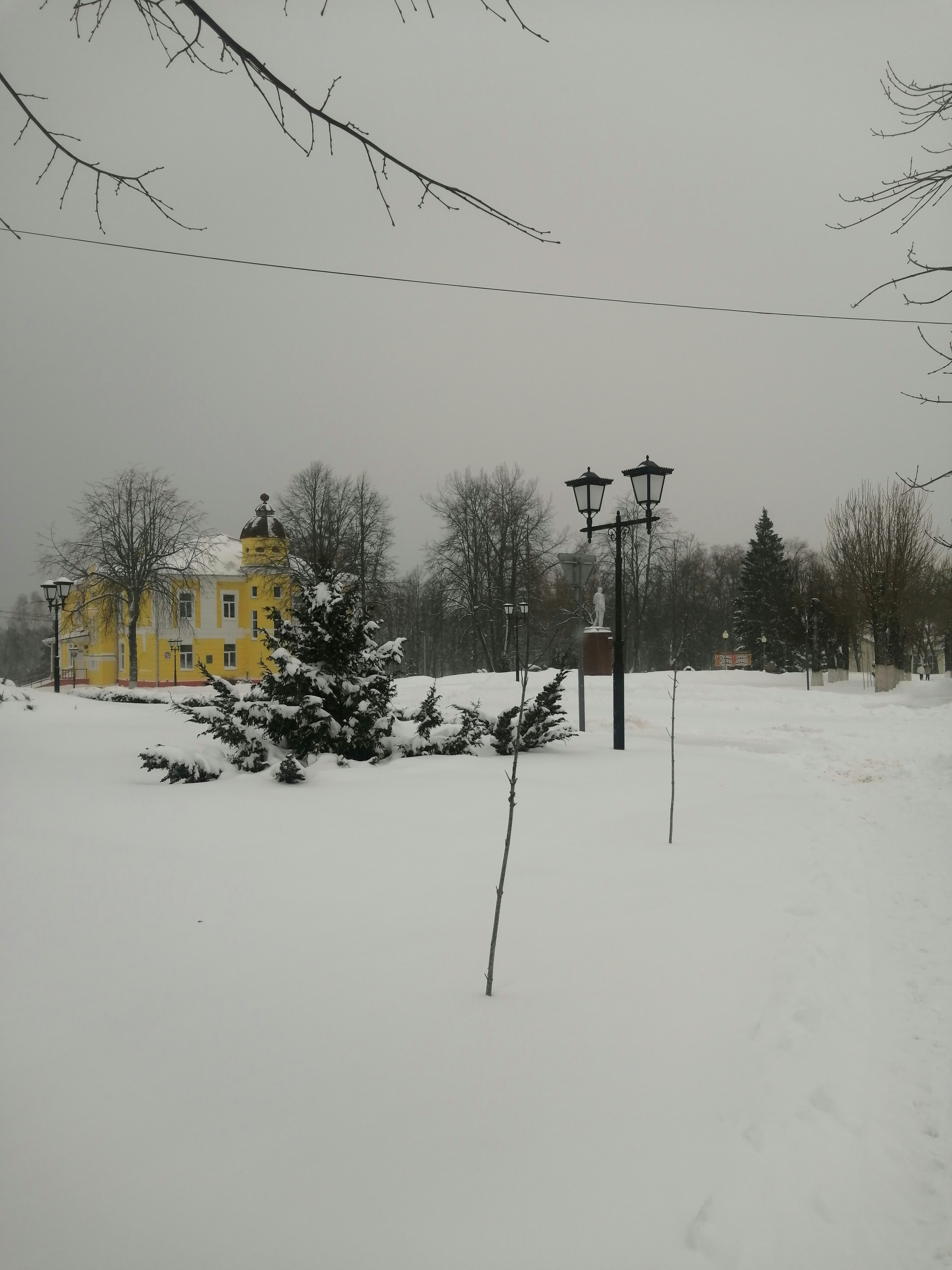 a yellow house in the middle of a snowy field