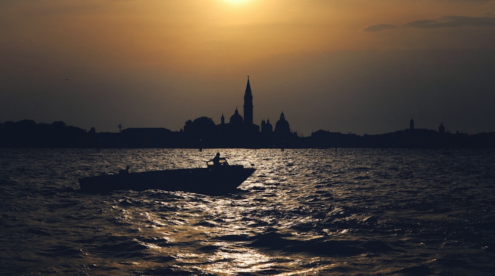 a boat in the water with a city in the background