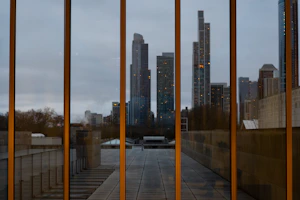 Close-up of sleek glass panels reflecting a modern city skyline under bright daylight.