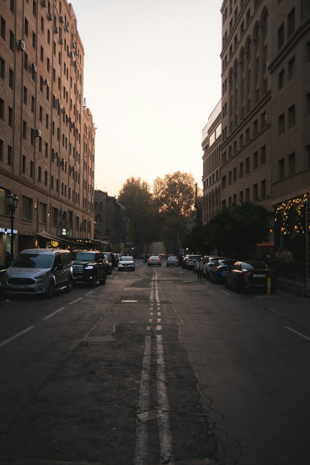 a city street lined with tall buildings and parked cars