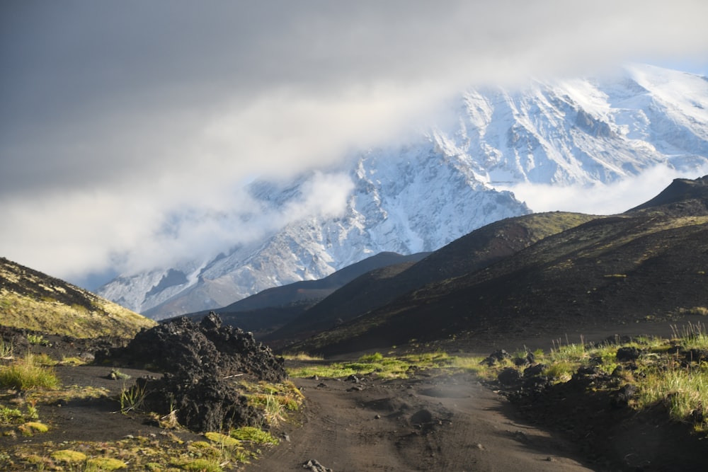 a dirt road with a mountain in the background