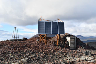 A sleek industrial battery system installed at a remote mining site surrounded by rugged terrain.