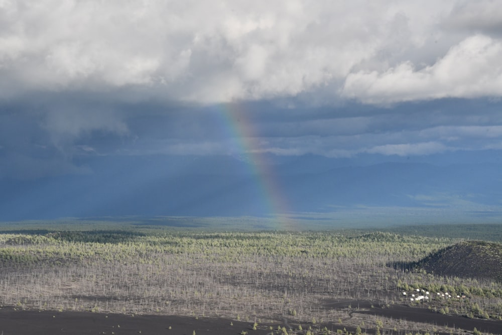 a rainbow in the sky over a field