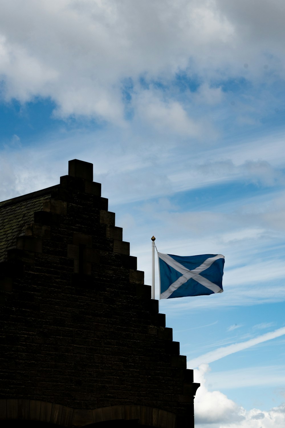 a blue and white flag flying over a brick building