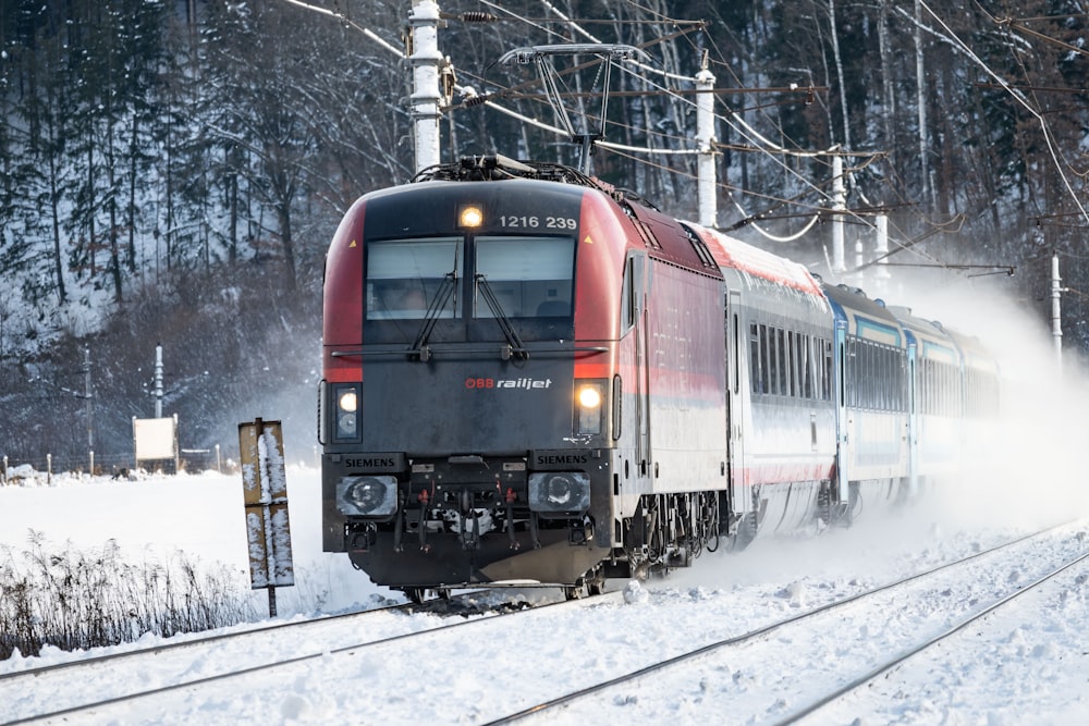 a red and black train traveling down train tracks