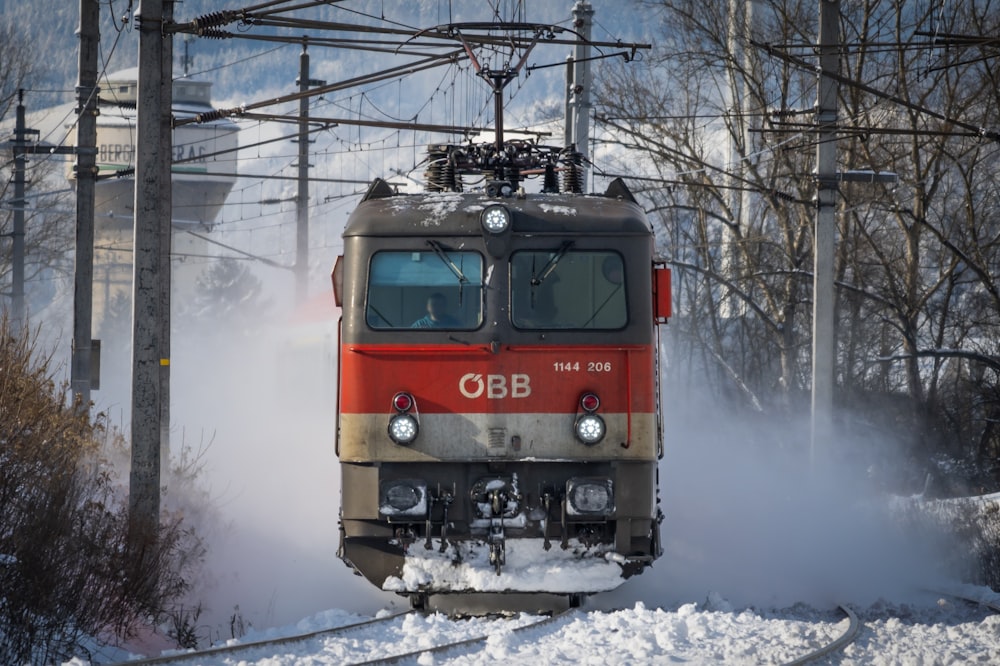 a red and silver train traveling down train tracks