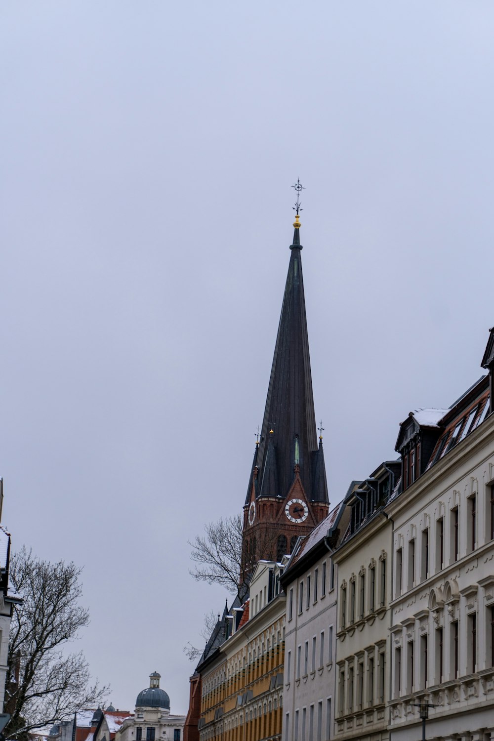 a church steeple towering over a row of buildings
