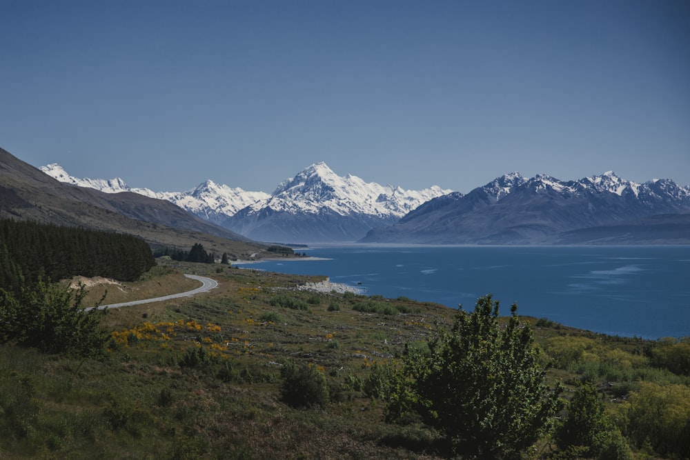 uma vista panorâmica de uma cordilheira com um lago em primeiro plano