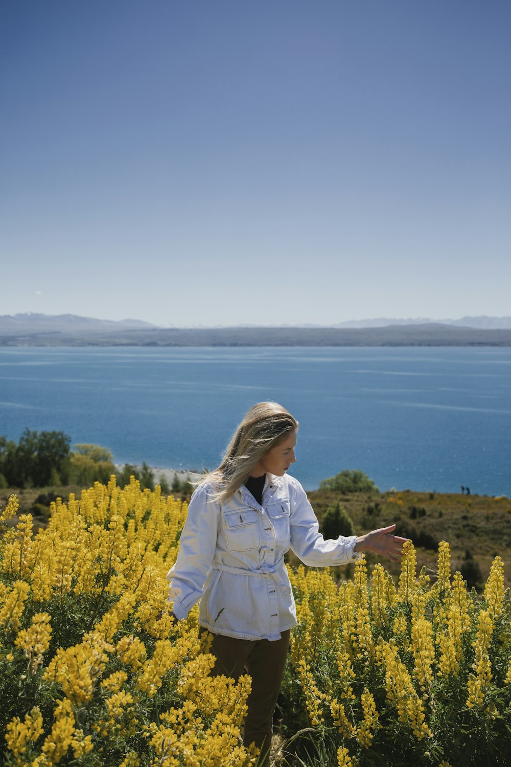 une femme debout dans un champ de fleurs jaunes