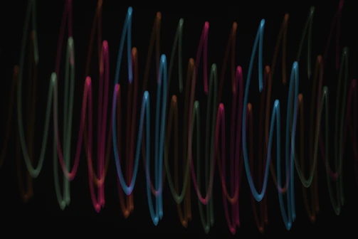 A cinematic waveform visualizer pulsing rhythmically against a dark background.