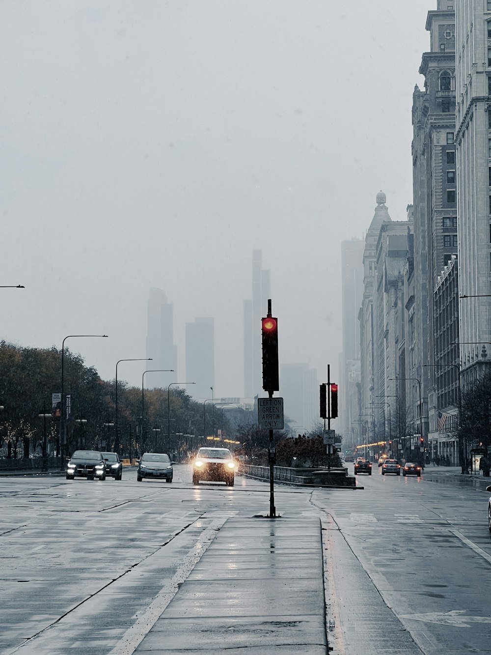 a city street filled with lots of traffic next to tall buildings