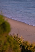 Front view of the Golden Sand Villa bathed in soft morning light with a sandy path leading up to the entrance.