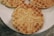 A close-up of waffles on a white plate, featuring a gingerbread man design imprinted in the center of each waffle. The waffles are golden brown with visible square patterns typical of their texture.