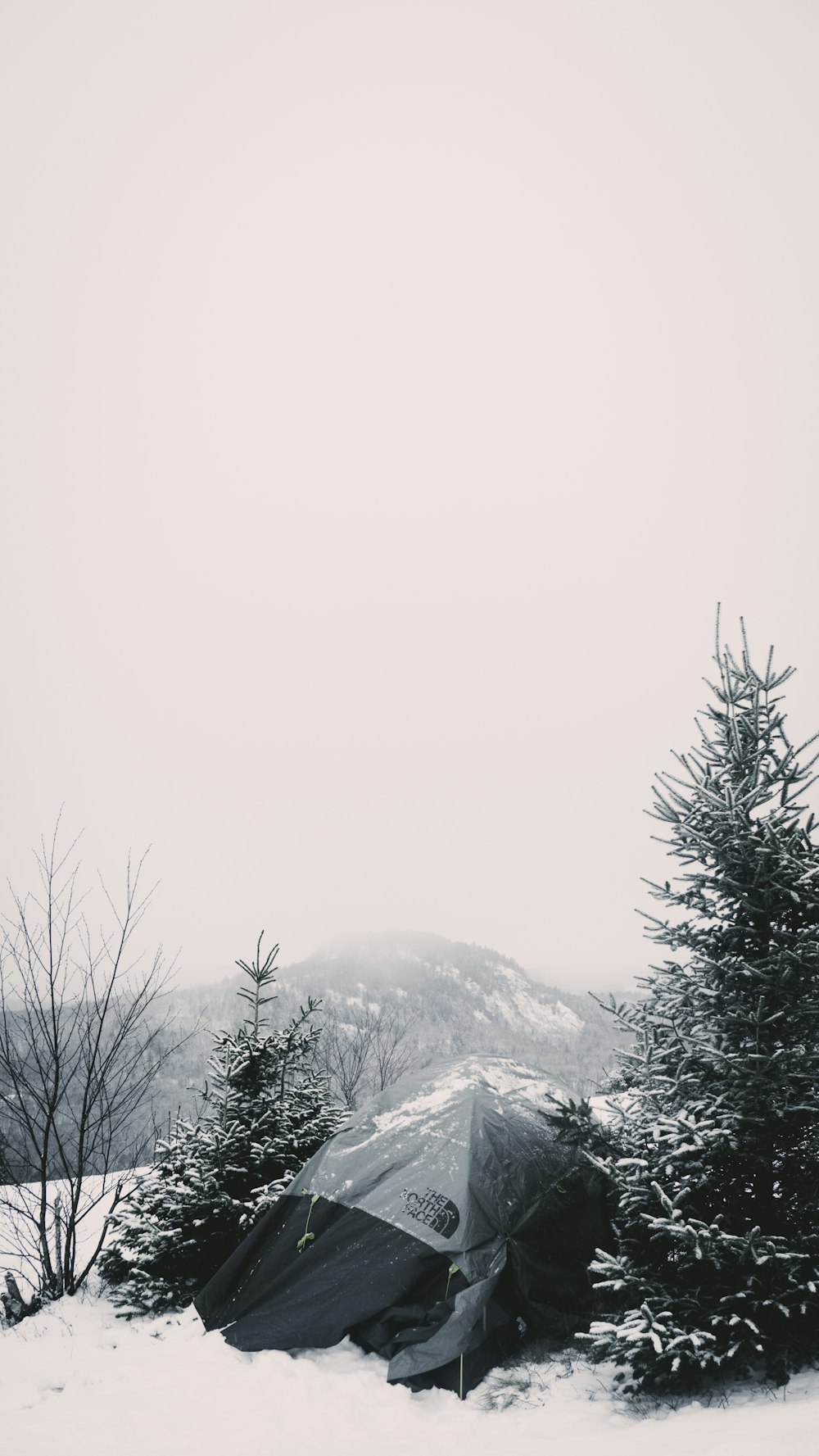 ein Zelt im Schnee mit einem Berg im Hintergrund