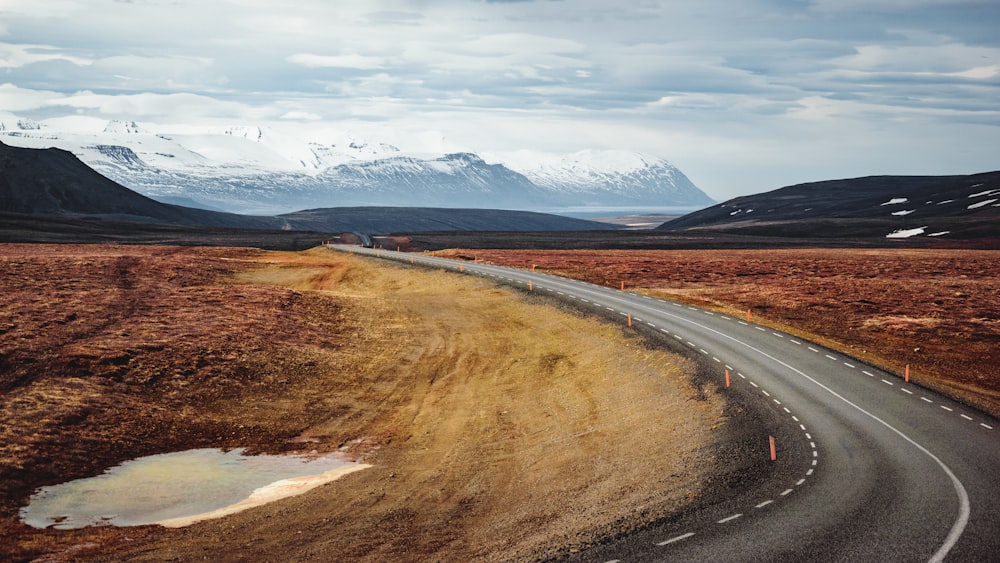 a road in the middle of nowhere with mountains in the background