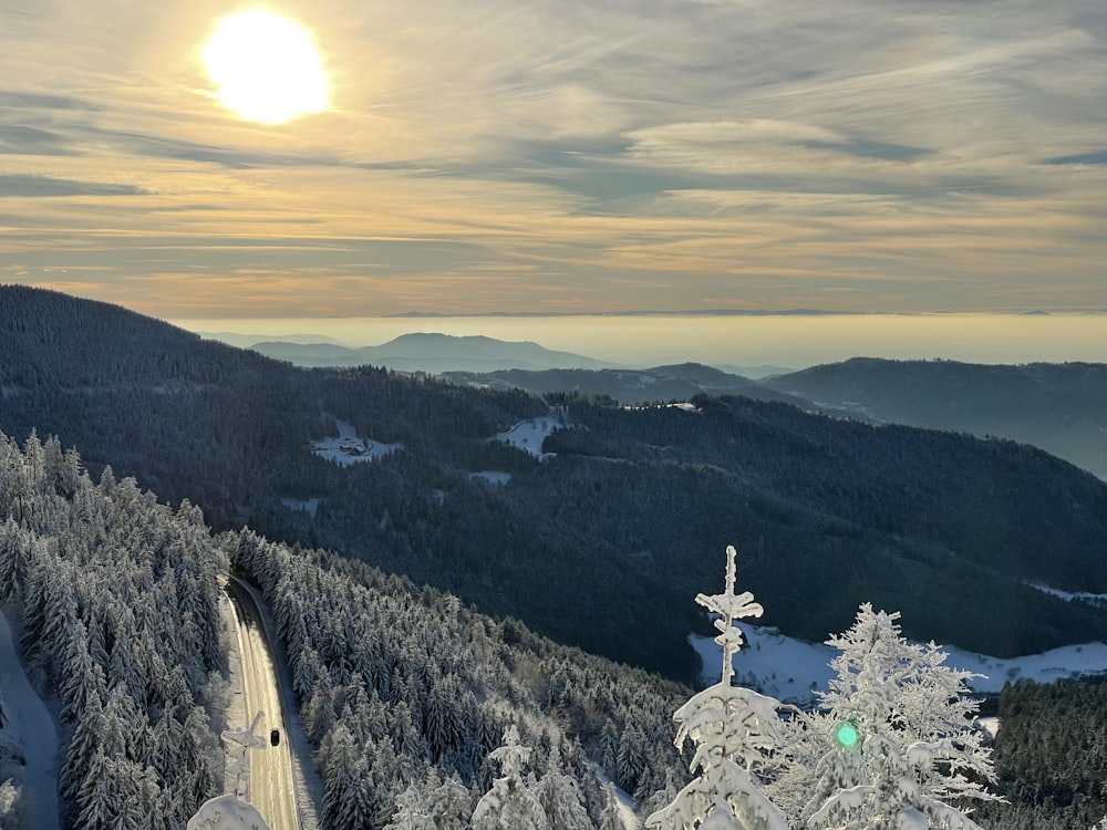 the sun is setting over a snowy mountain