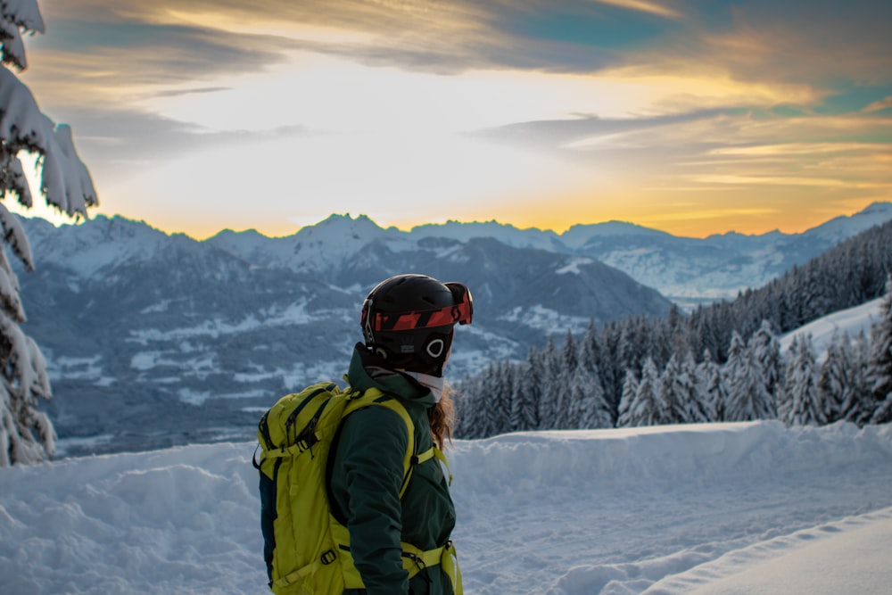 a person standing on top of a snow covered slope