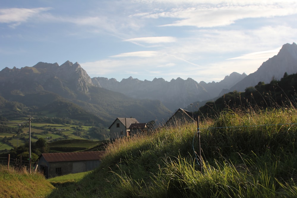 a house on a hill with mountains in the background