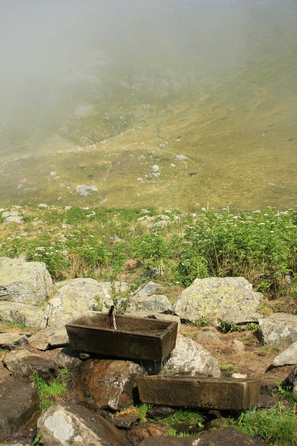 a wooden box sitting on top of a pile of rocks