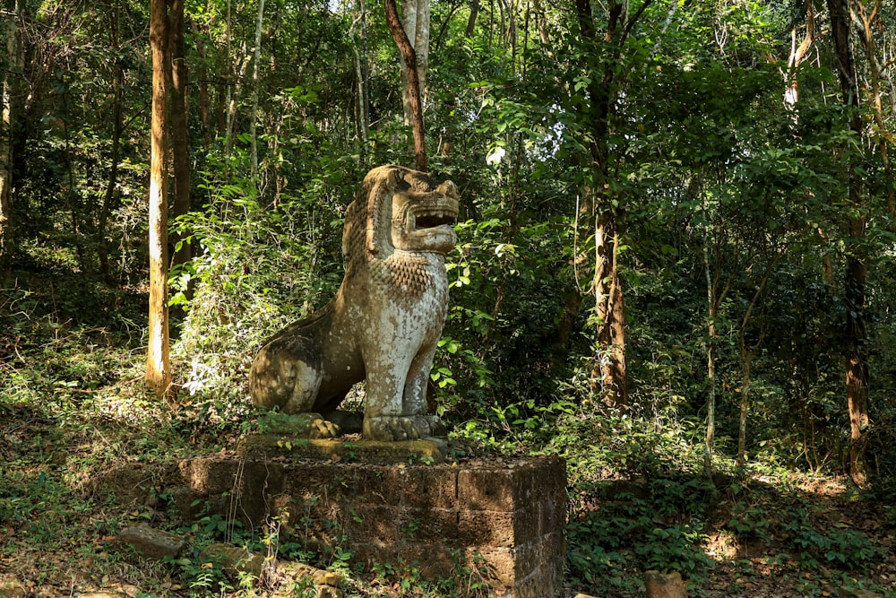 a statue of a dinosaur in the middle of a forest