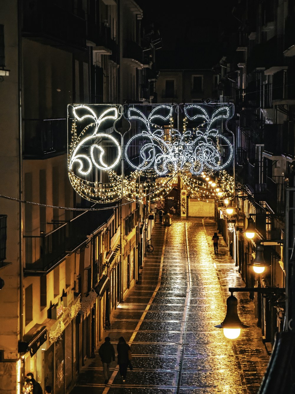 a city street is lit up with christmas lights