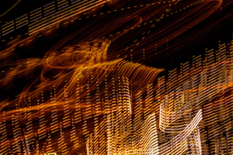 Close-up abstraction of warm golden light trails swirling over deep charcoal background symbolizing raw energy flow.