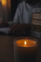A cozy writer's desk with an open notebook, quill, and candlelight.