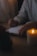 A serene close-up of a person thoughtfully journaling by candlelight.