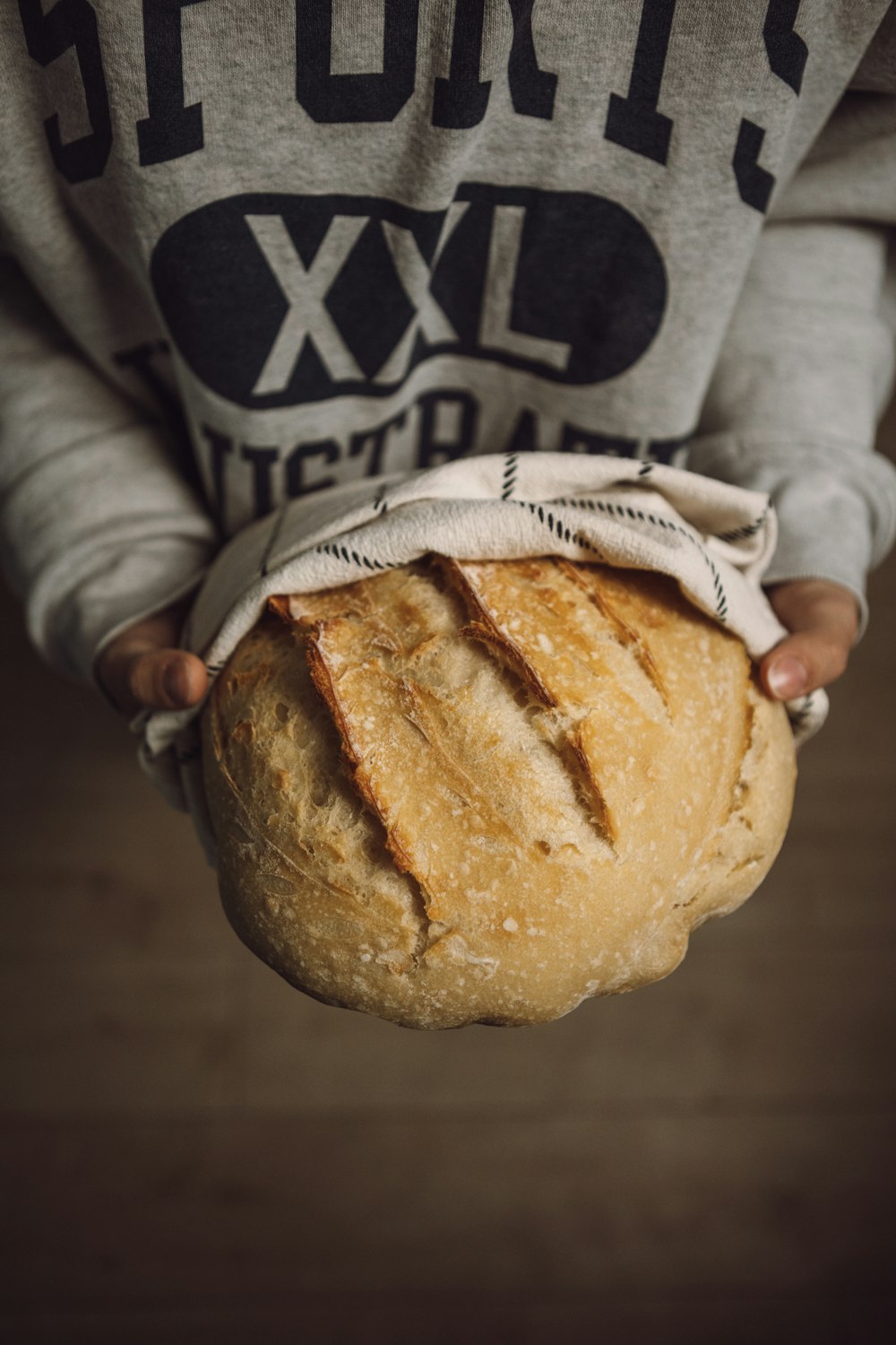 a person holding a loaf of bread in their hands