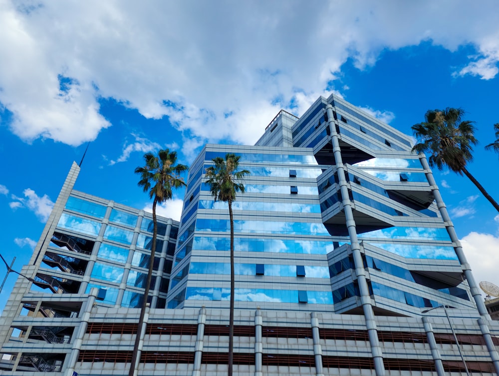 a very tall building with palm trees in front of it